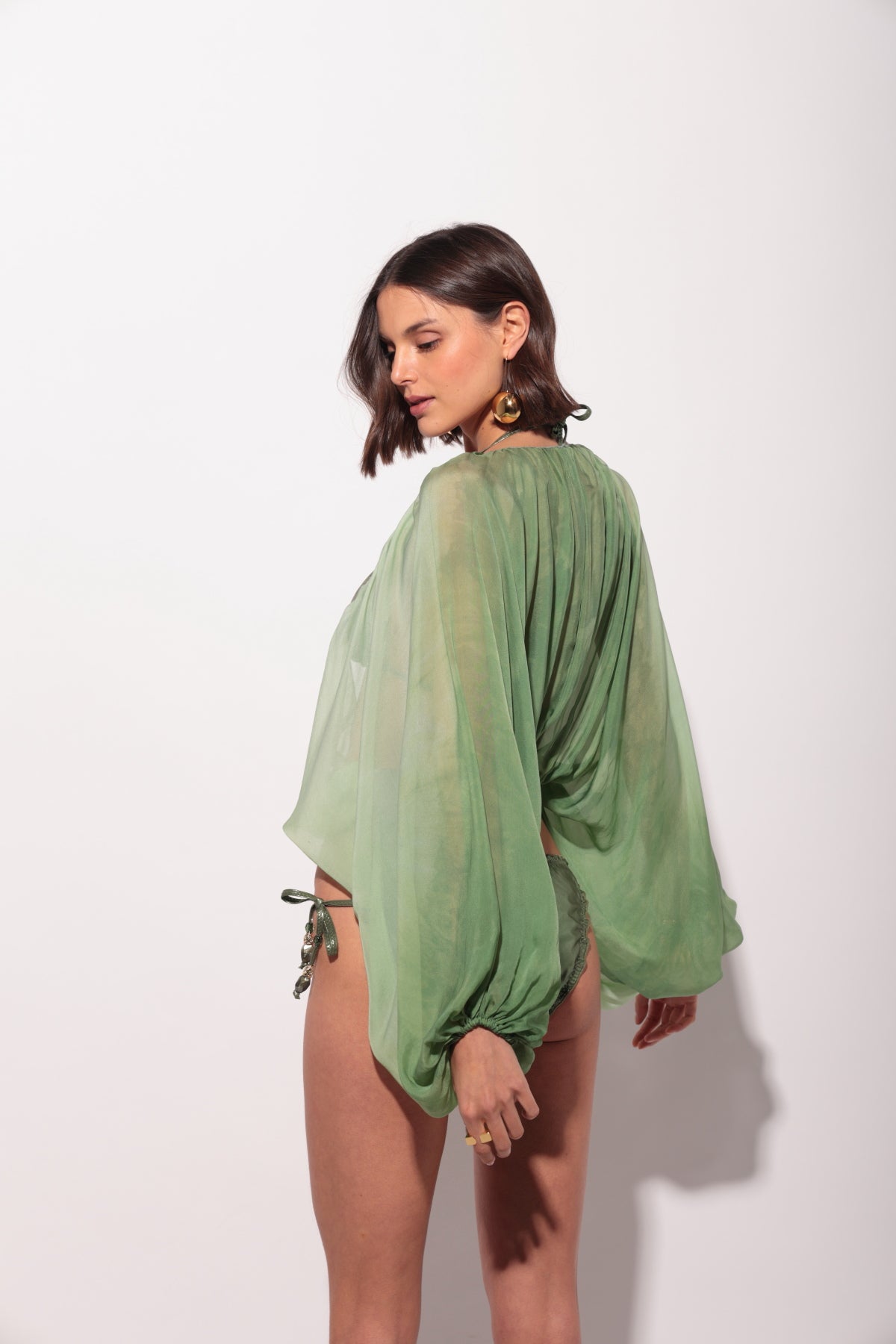 Blusa verde manga larga holgada con anilla dorada en el delantero