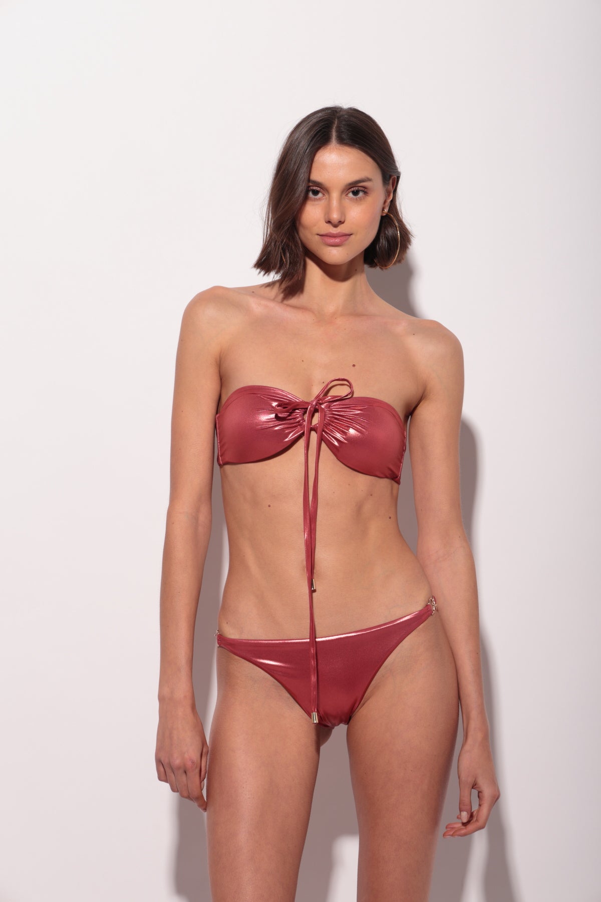 Bikini rosa bandeau metálico con lágrima y frunce central y braguita con aros dorados en los laterales